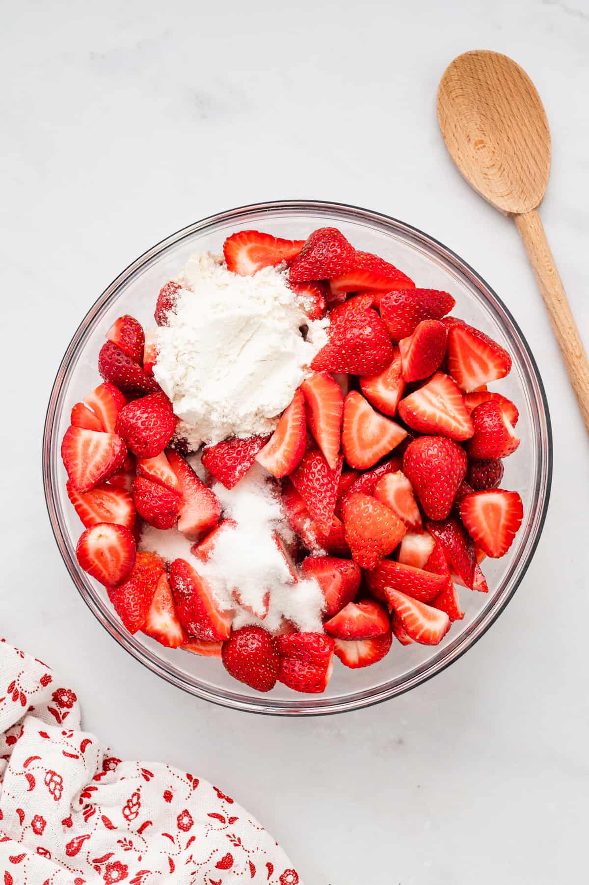 Combining fresh prepared strawberries and other filling ingredients in mixing bowl for Strawberry Crisp