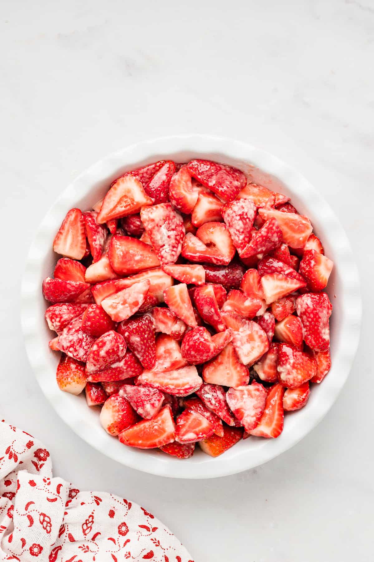 Lining round baking dish with prepared strawberries for Strawberry Crisp