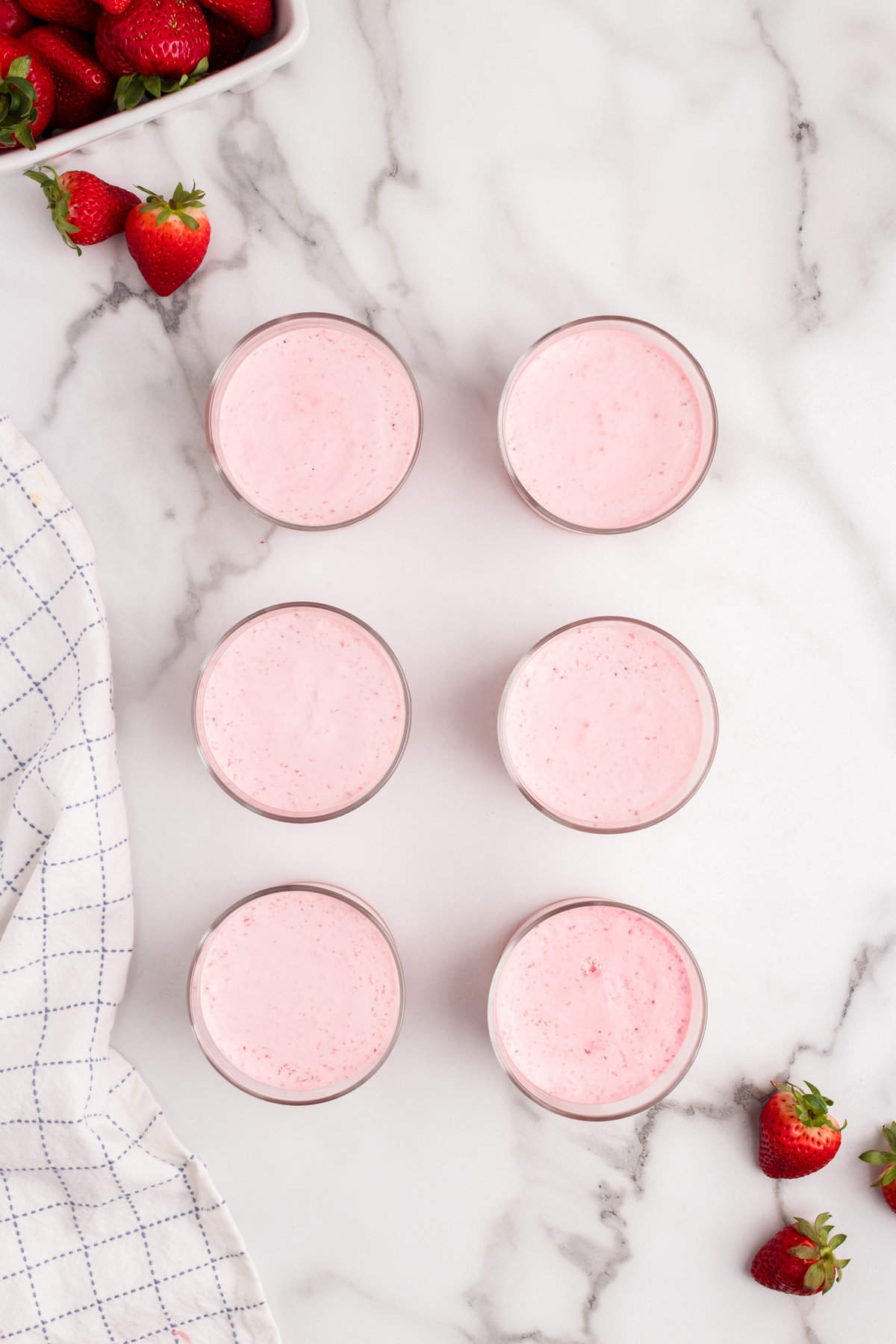 Adding the creamy puree over the strawberry puree in smal glass