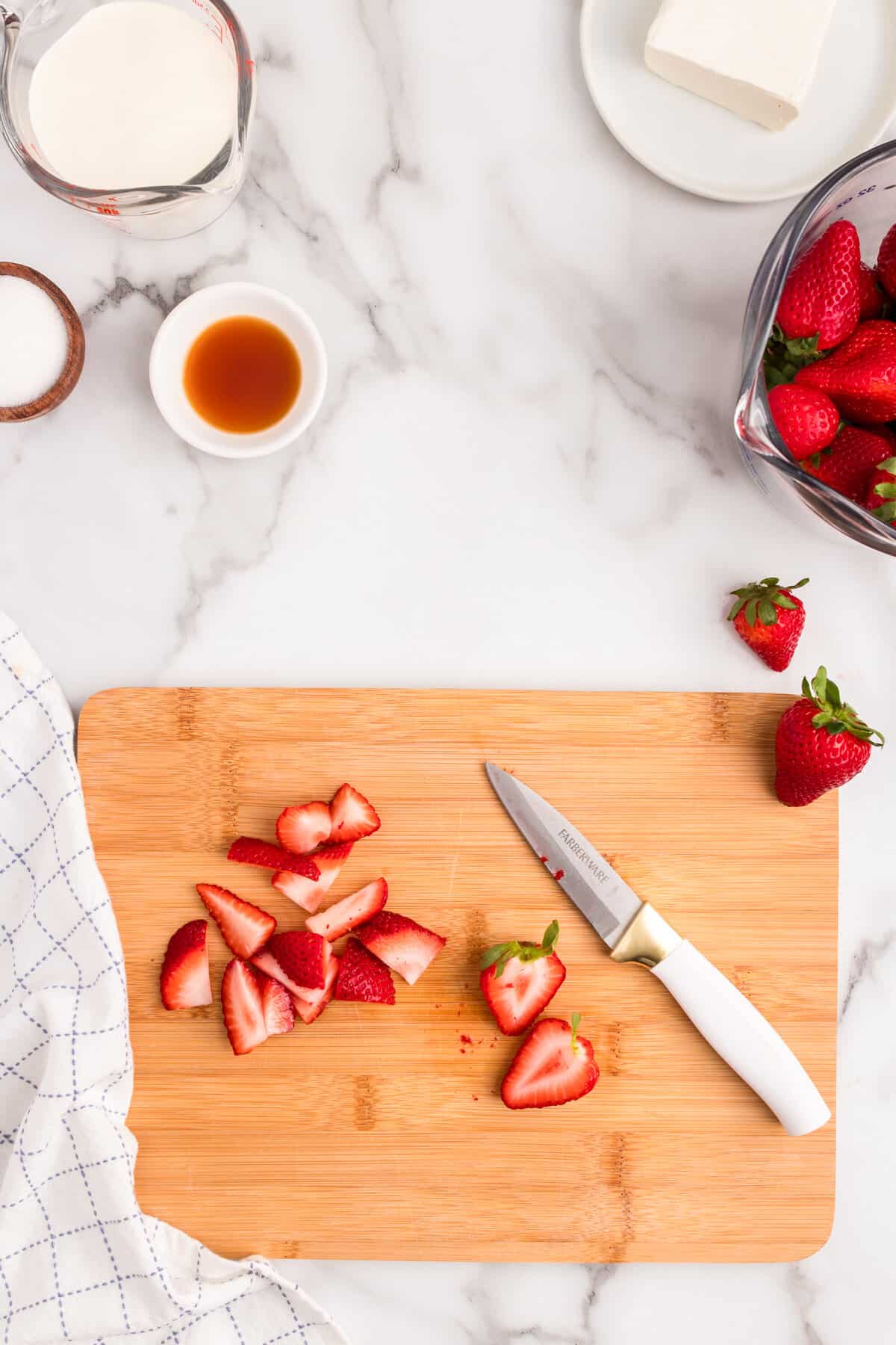 Slicing strawberries on wooden cutting board for Strawberry Mousse recipe