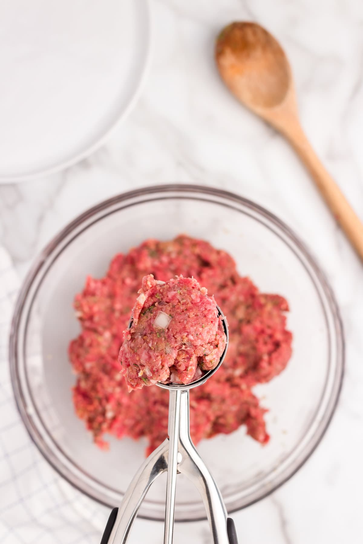 Ground beef with seasoning mixed in for Swedish Meatball Casserole recipe with scoop of meatball