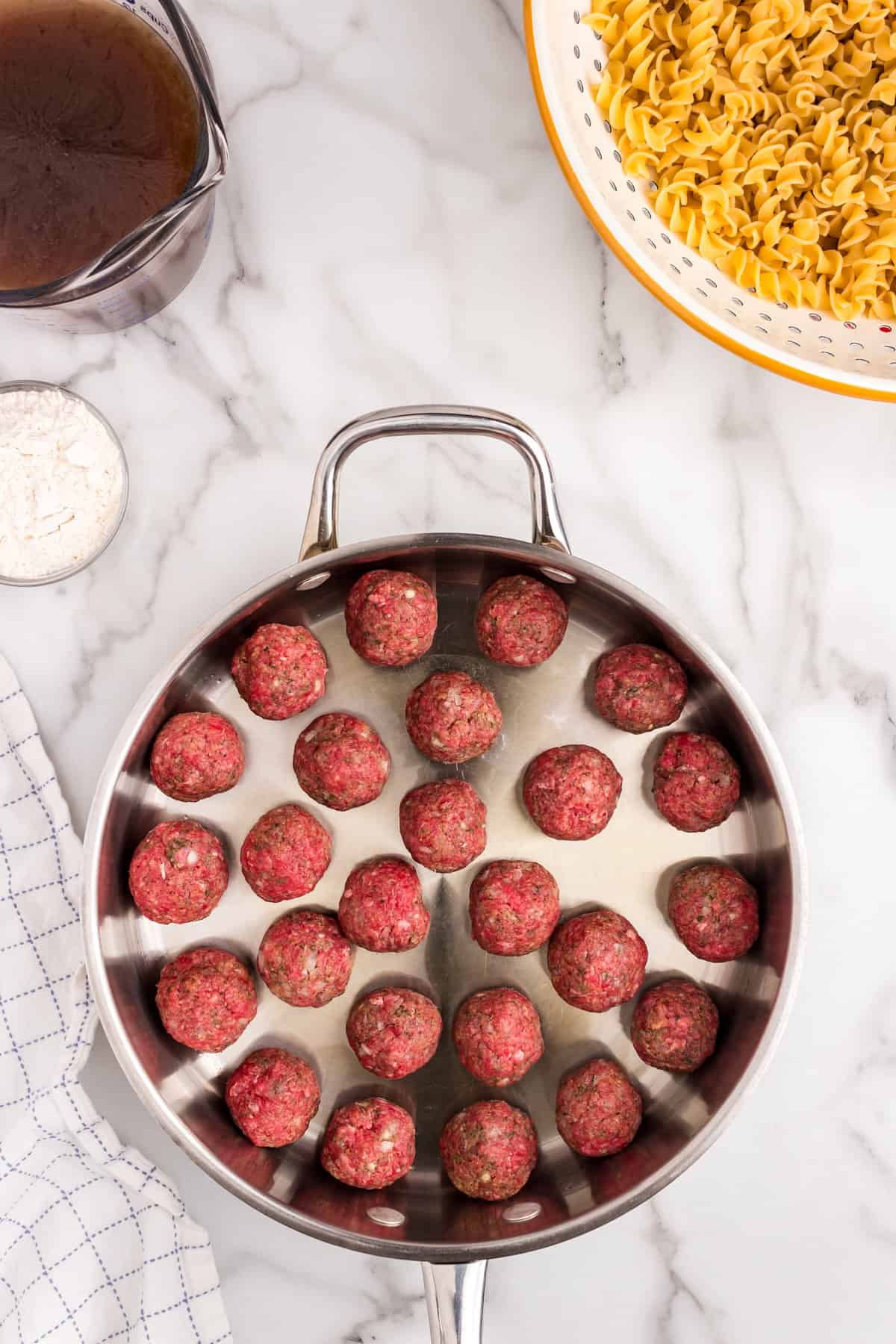 Meatballs in stovetop skillet for Swedish Meatball Casserole recipe