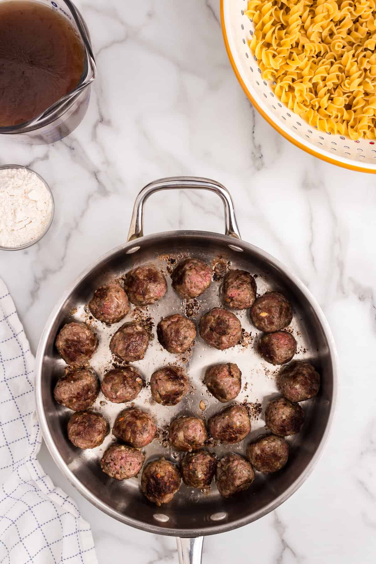 Meatballs in stovetop skillet for Swedish Meatball Casserole recipe