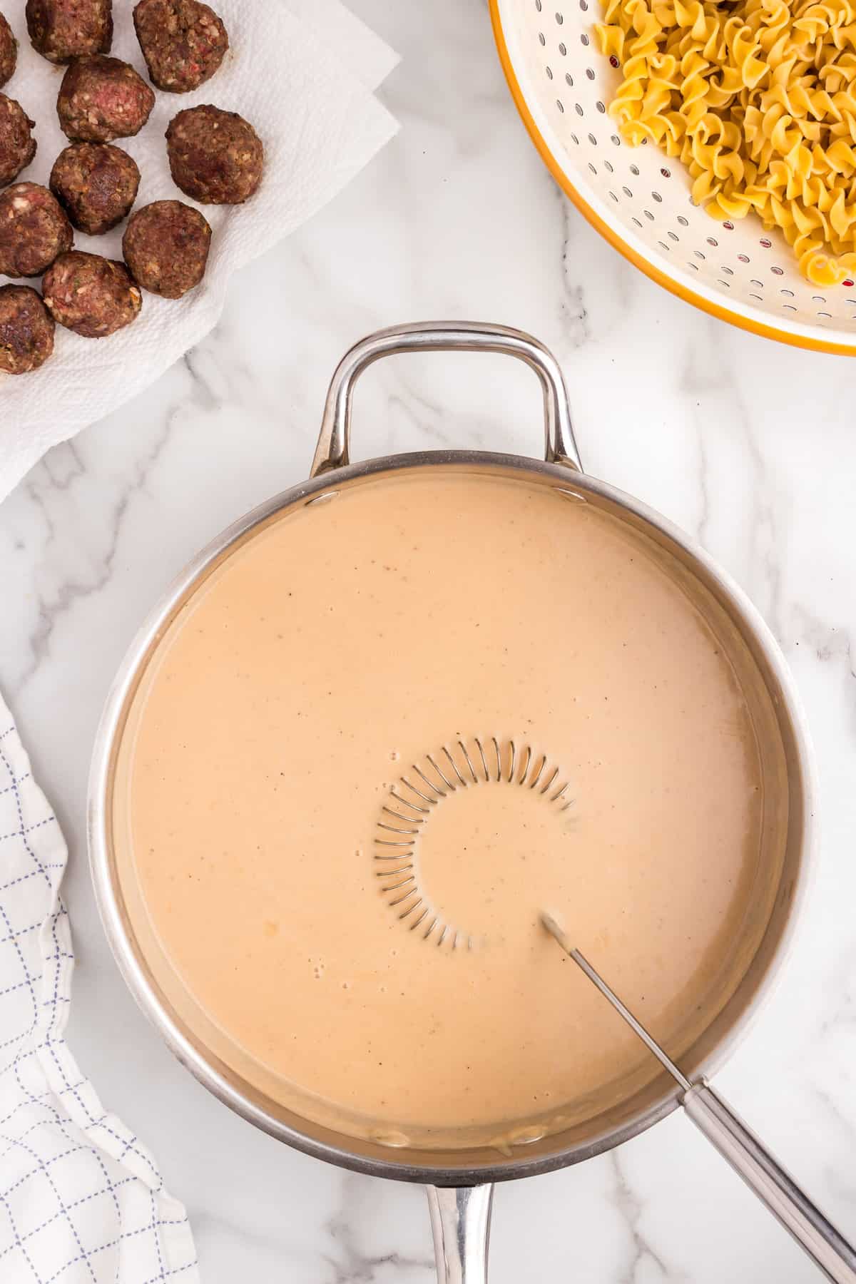 Whisking Ingredients for Swedish Meatball Casserole gracy in stovetop skillet