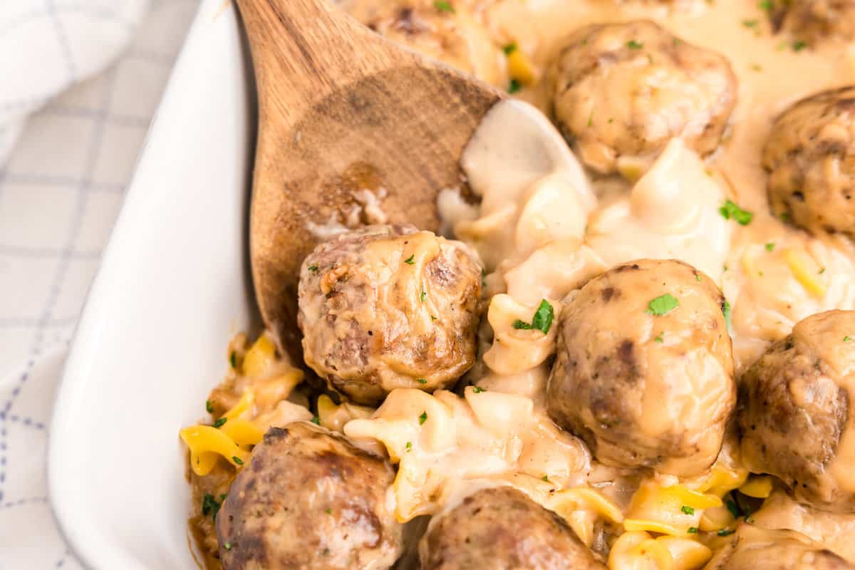 Swedish Meatball Casserole in baking dish with wooden spoon