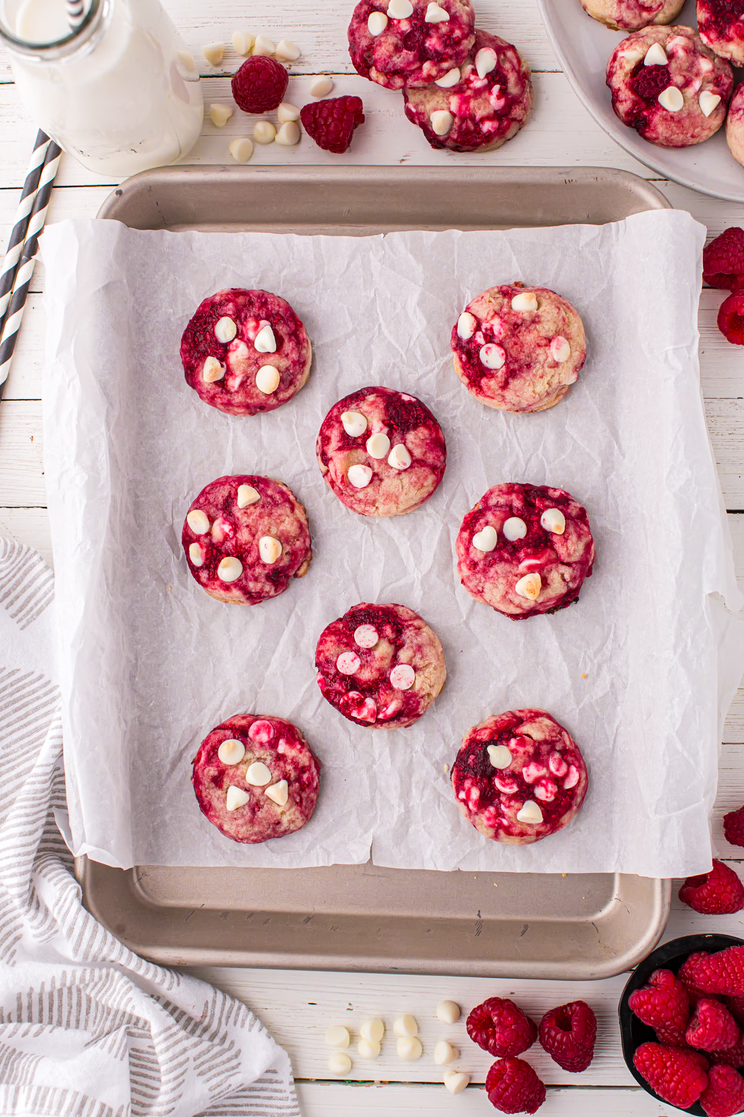 White Chocolate Raspberry Cookies just out of the oven on a parchment-lined cookie sheet