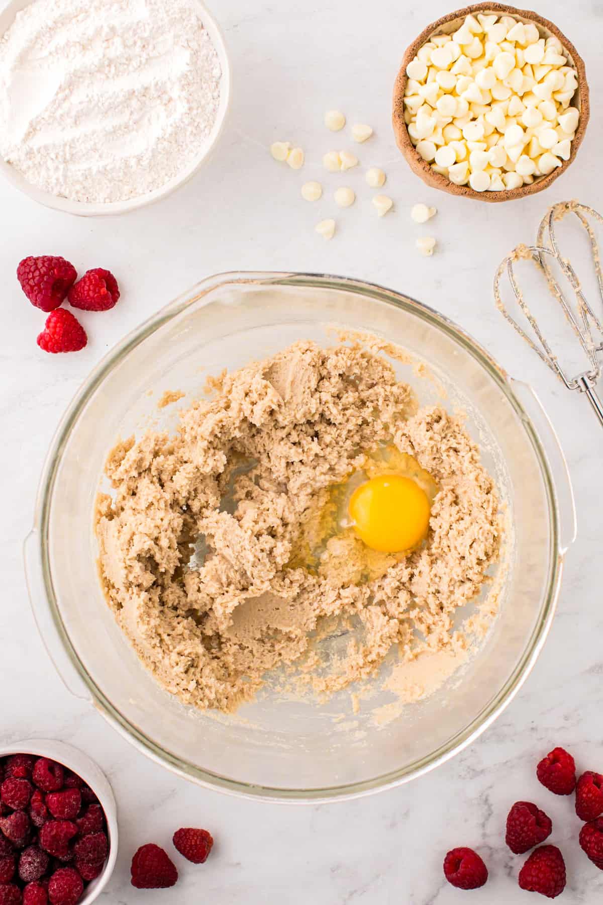 Adding egg to creamed sugar and butter mixture for Raspberry White Chocolate Cookies