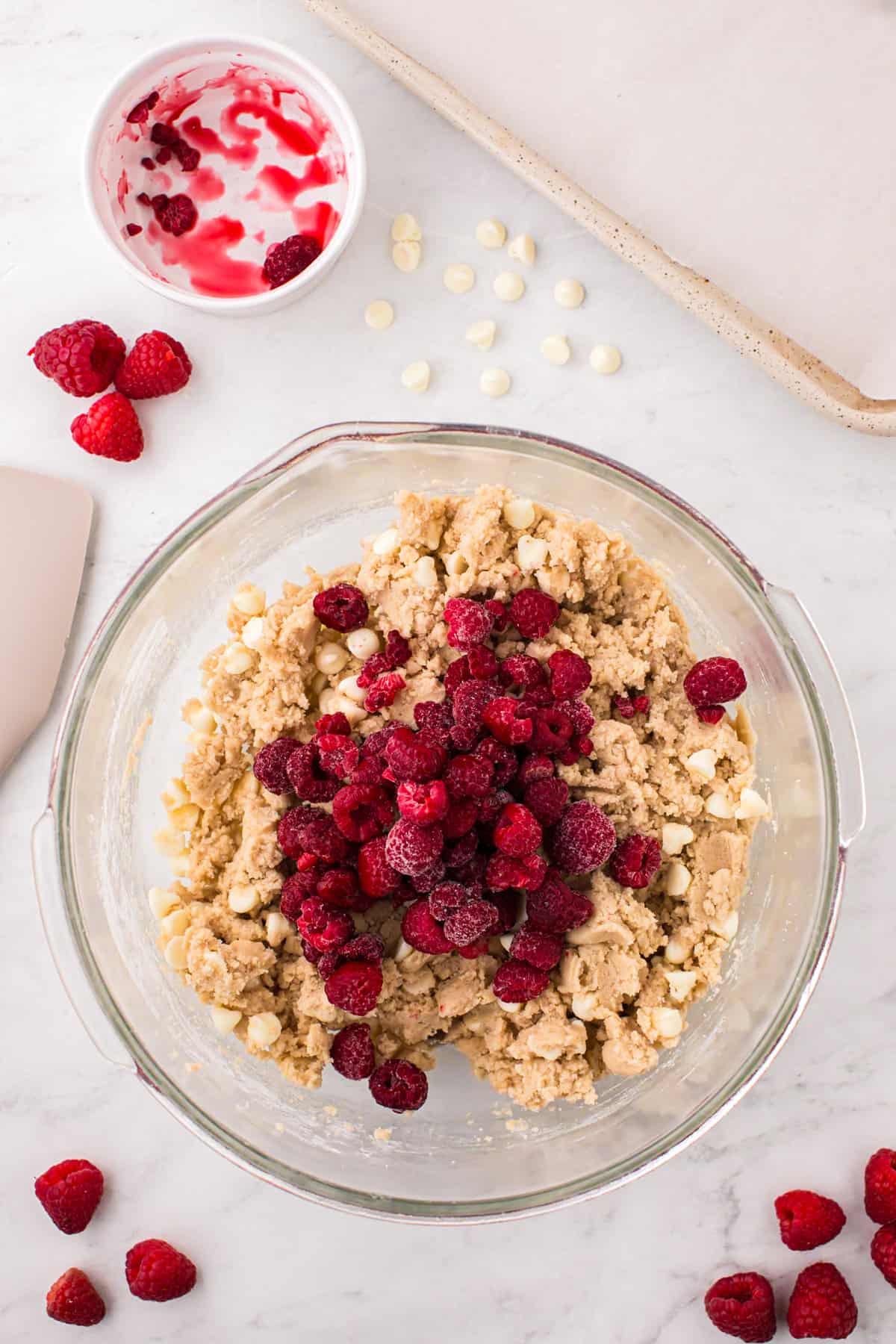 Adding raspberries to cookie dough in mixing bowl for White Chocolate Raspberry Cookies