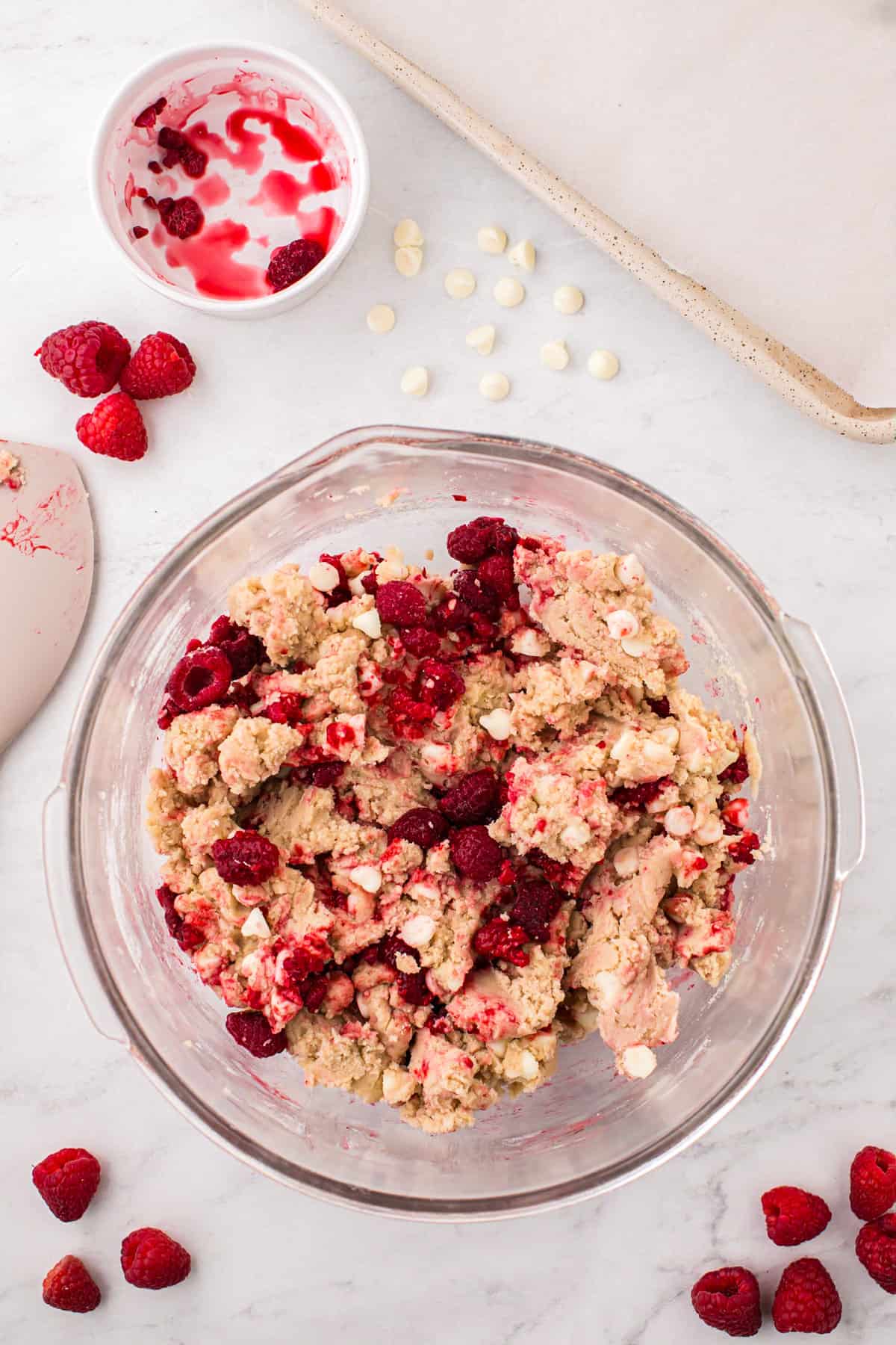 Combined cookie dough and raspberries in mixing bowl for White Chocolate Raspberry Cookies