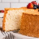 Closeup square image of Angel Food Cake being cut from cake and slice removed
