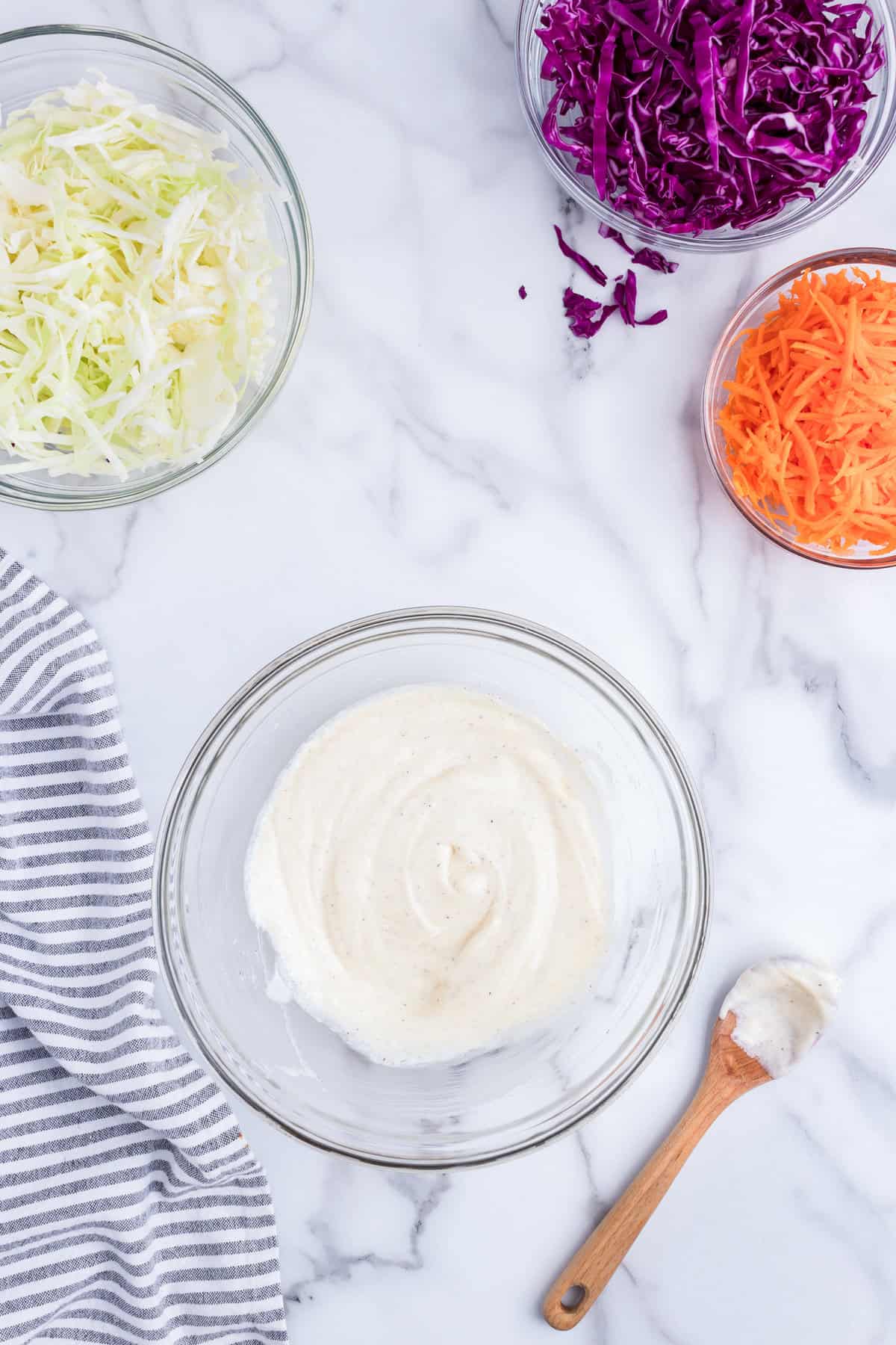 Combined Creamy Coleslaw ingredients in glass mixing bowl