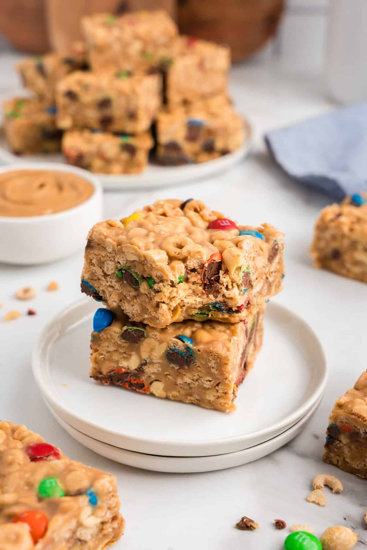 a White plate with two cereal bars, one on top of the other, with the top one having a bite taken out of it.