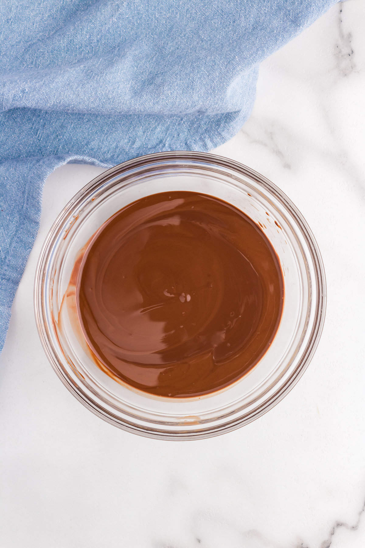 Melted semi-sweet chocolate chips and coconut oil in mixing bowl for Homemade Magic Shell recipe