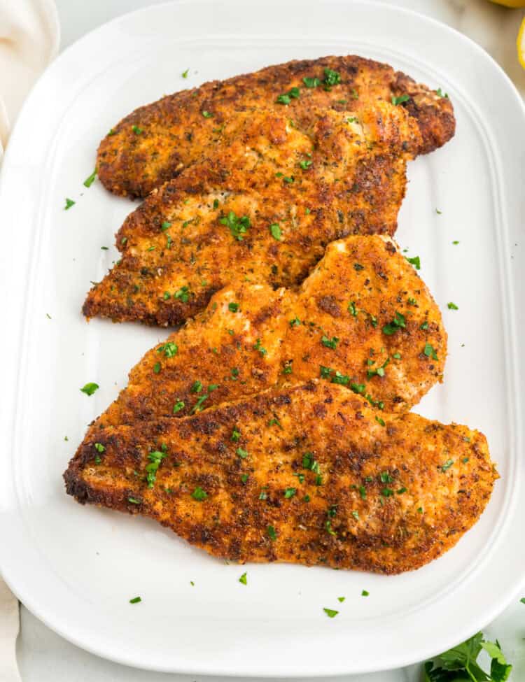 Parmesan Crusted Chicken arranged on white serving plate