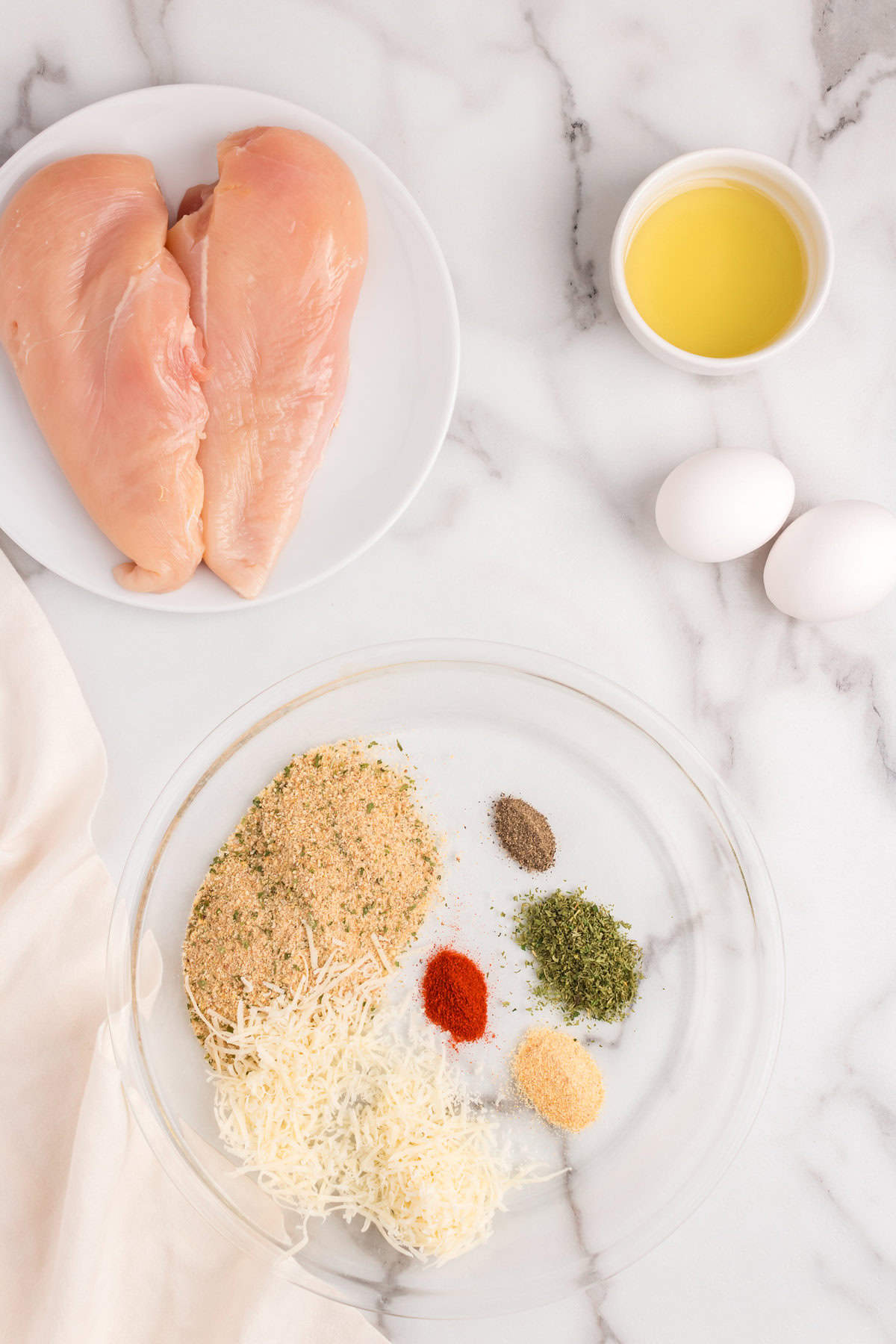 Seasoning ingredients in shallow glass mixing bowl for Parmesan Crusted Chicken recipe