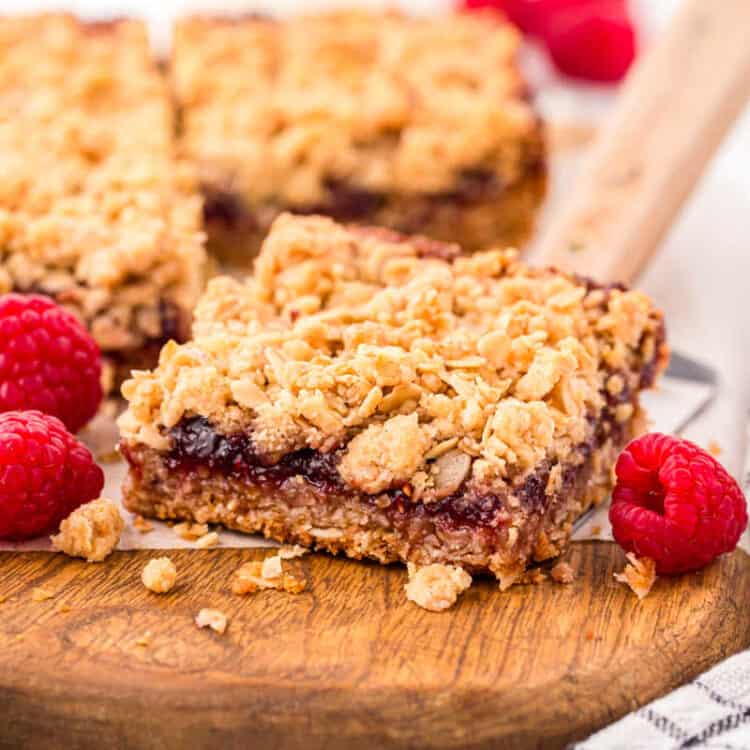 Raspberry Crumble Bars cut into a square on cutting board