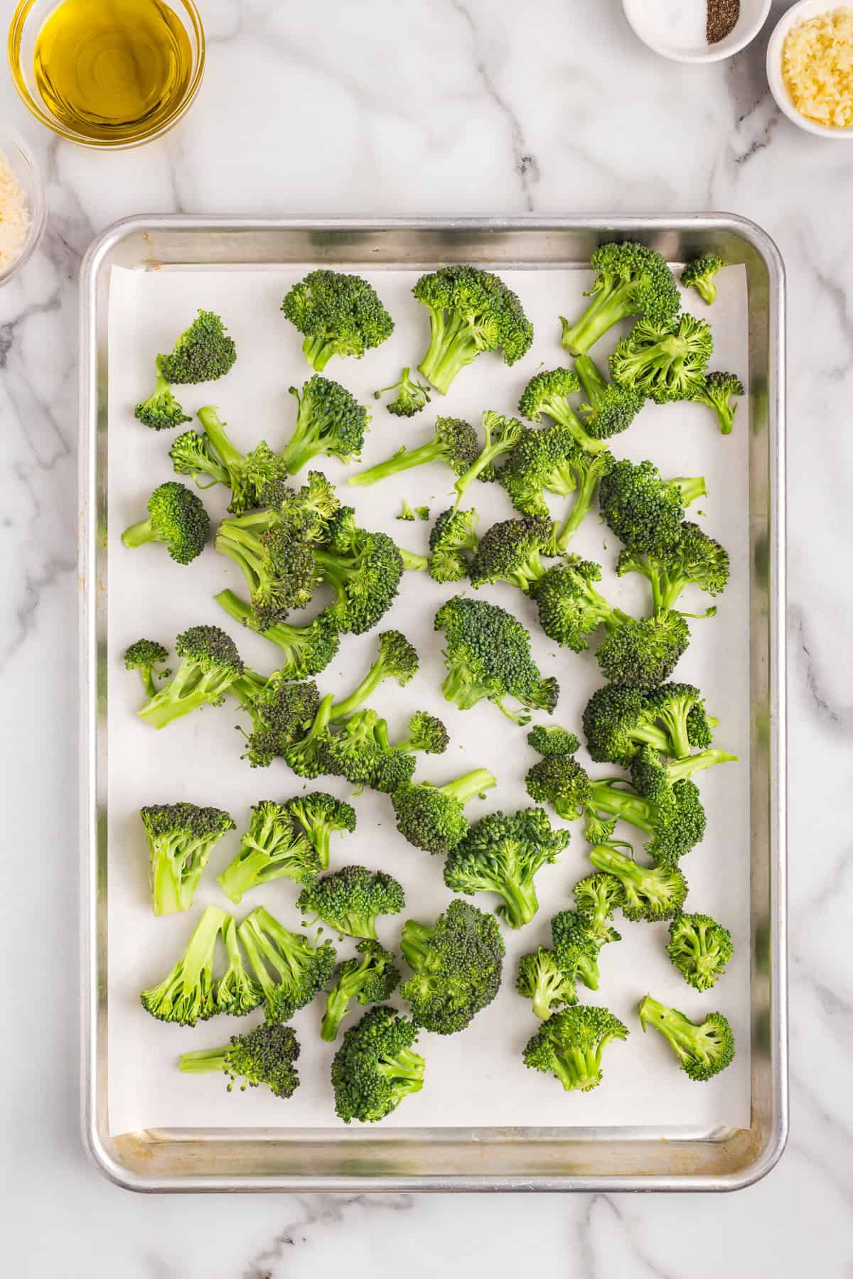 Broccoli florets on parchment-lined cooking sheet for Roasted Broccoli recipe