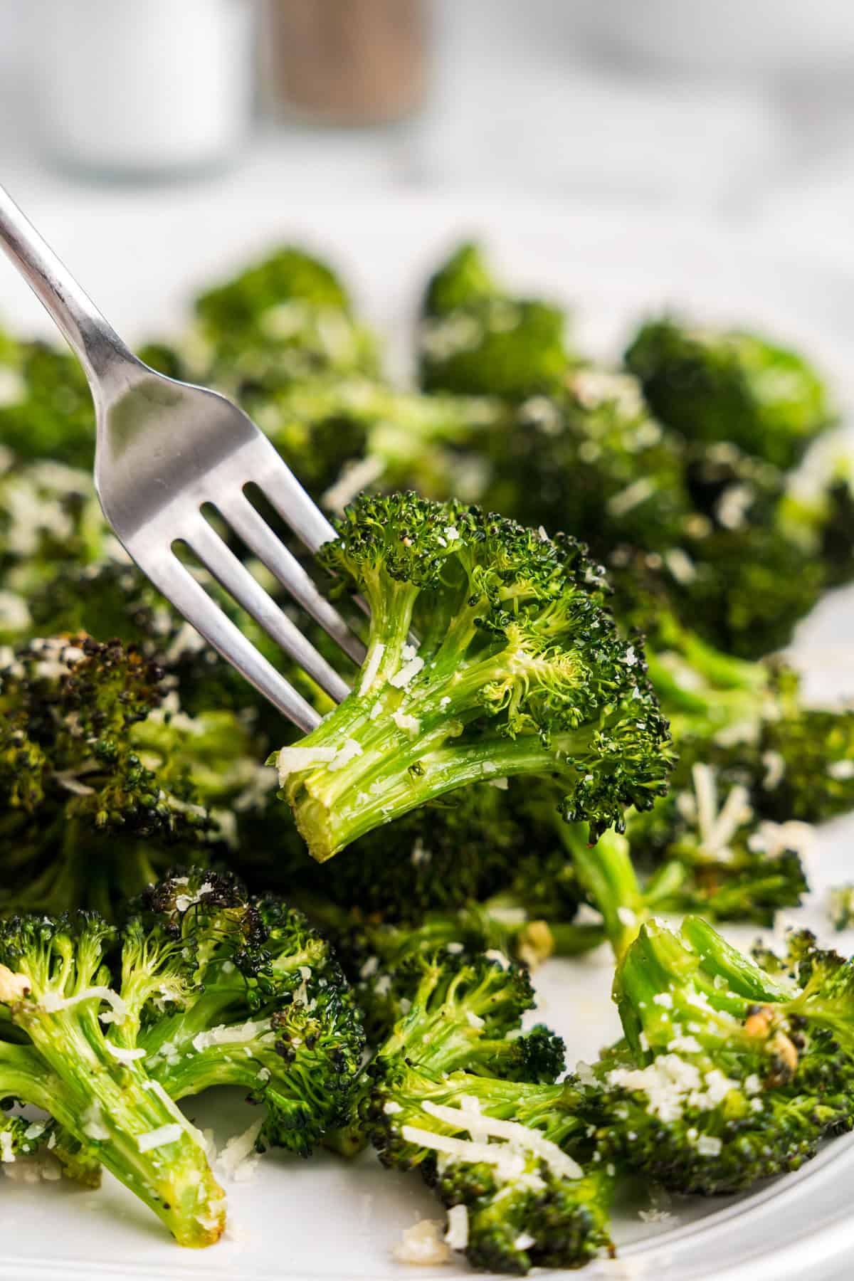 Oven Roasted Broccoli recipe on plate with fork ready to try to the first bite