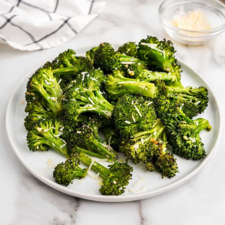 Roasted Broccoli topped with grated parmesan cheese on plate