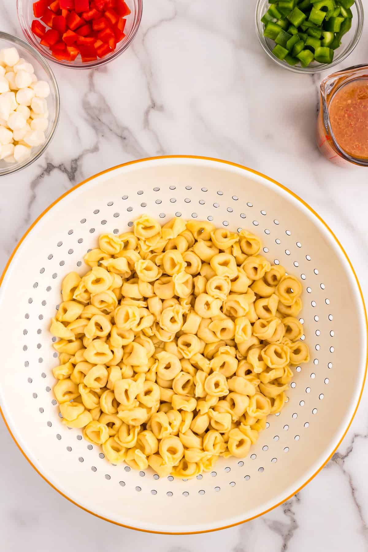 Cooked tortellini pasta in strainer for Tortellini Pasta Salad