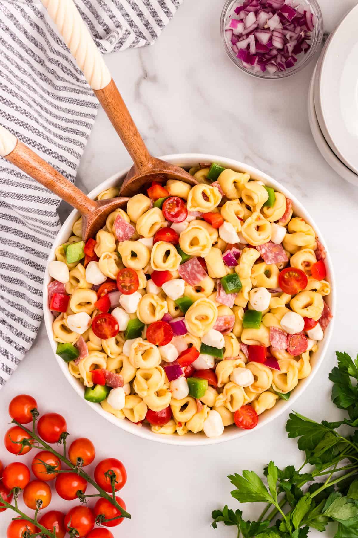 Tortellini Pasta Salad in serving bowl with wooden spoons