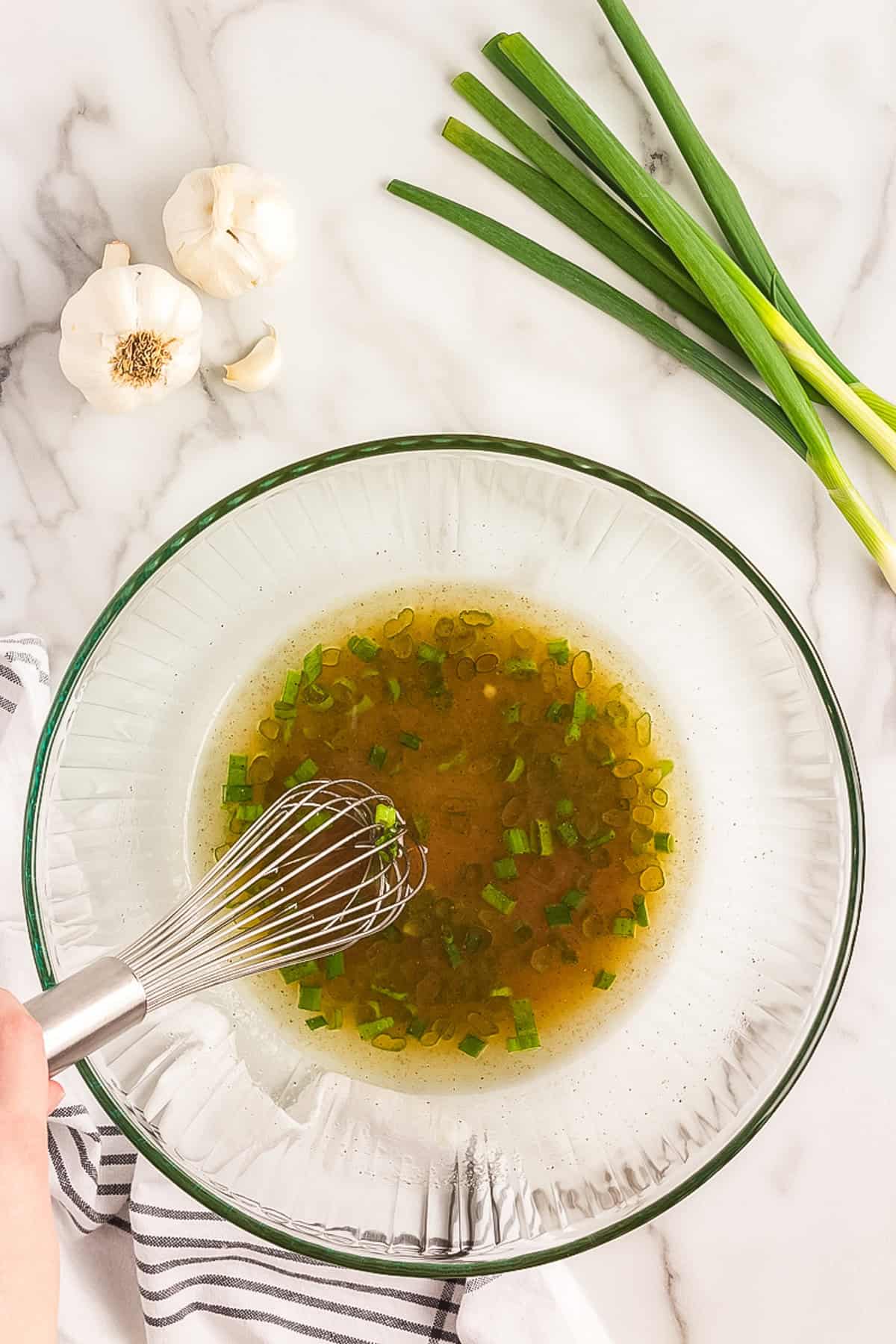 Whisking together Asian Ramen Salad dressing ingredients in glass mixing bowl