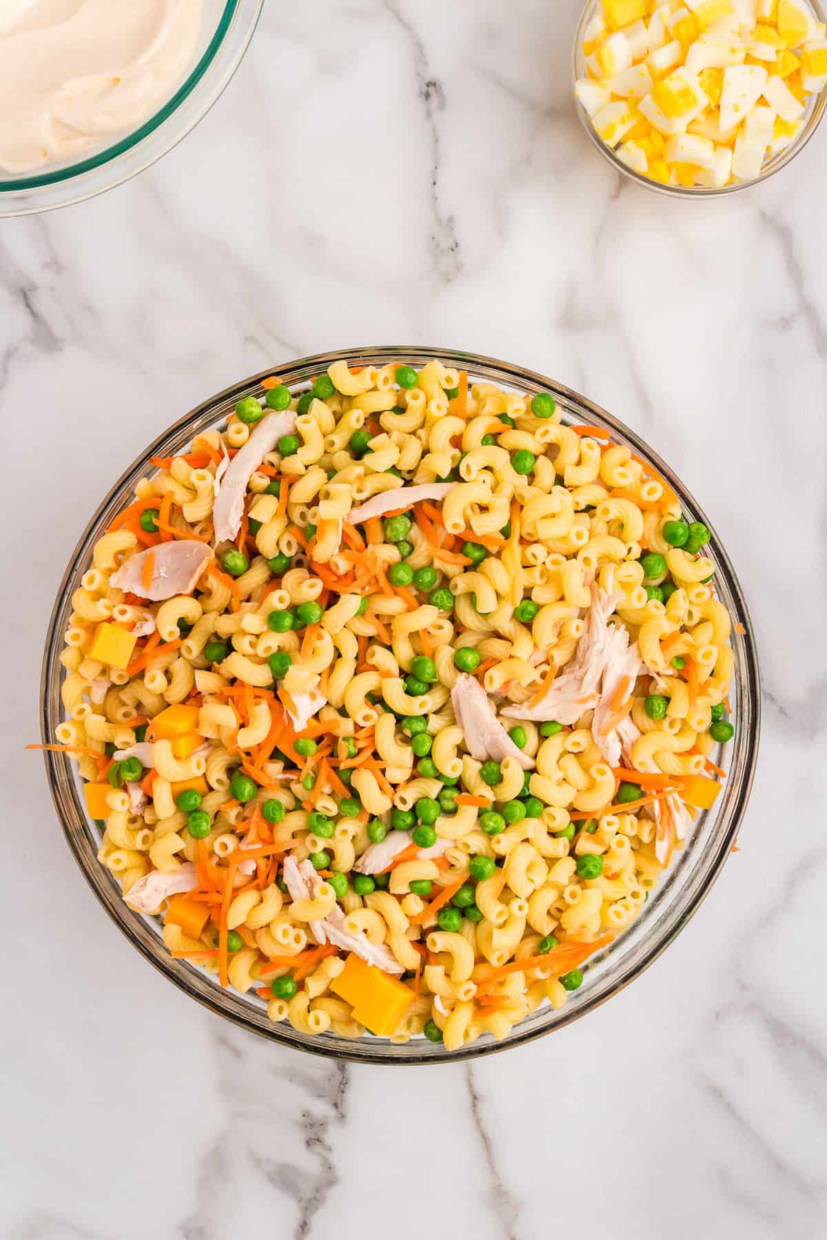 Tossing ingredients for Chicken Macaroni Salad in large bowl