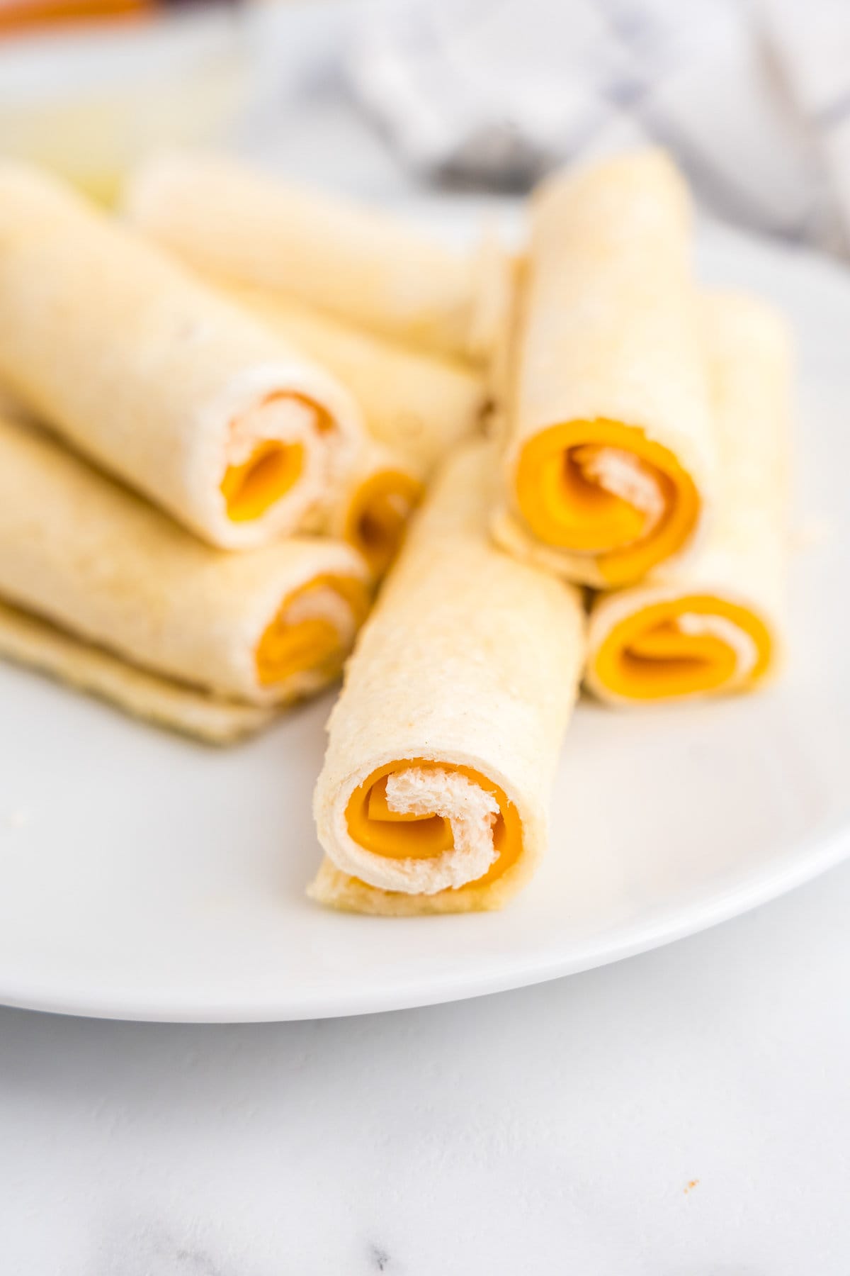 Carefully roll each slice of bread to the end nd brush with butter.