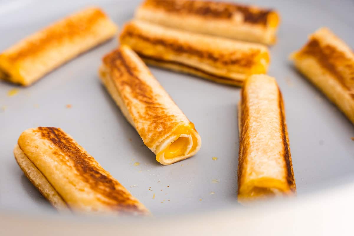 Close up of roll ups cooking in the pan.