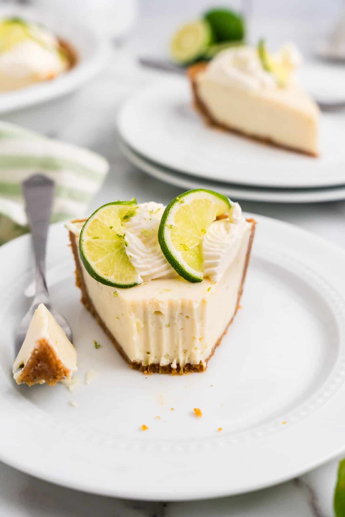Key Lime Pie slice on plate with one forkful taken
