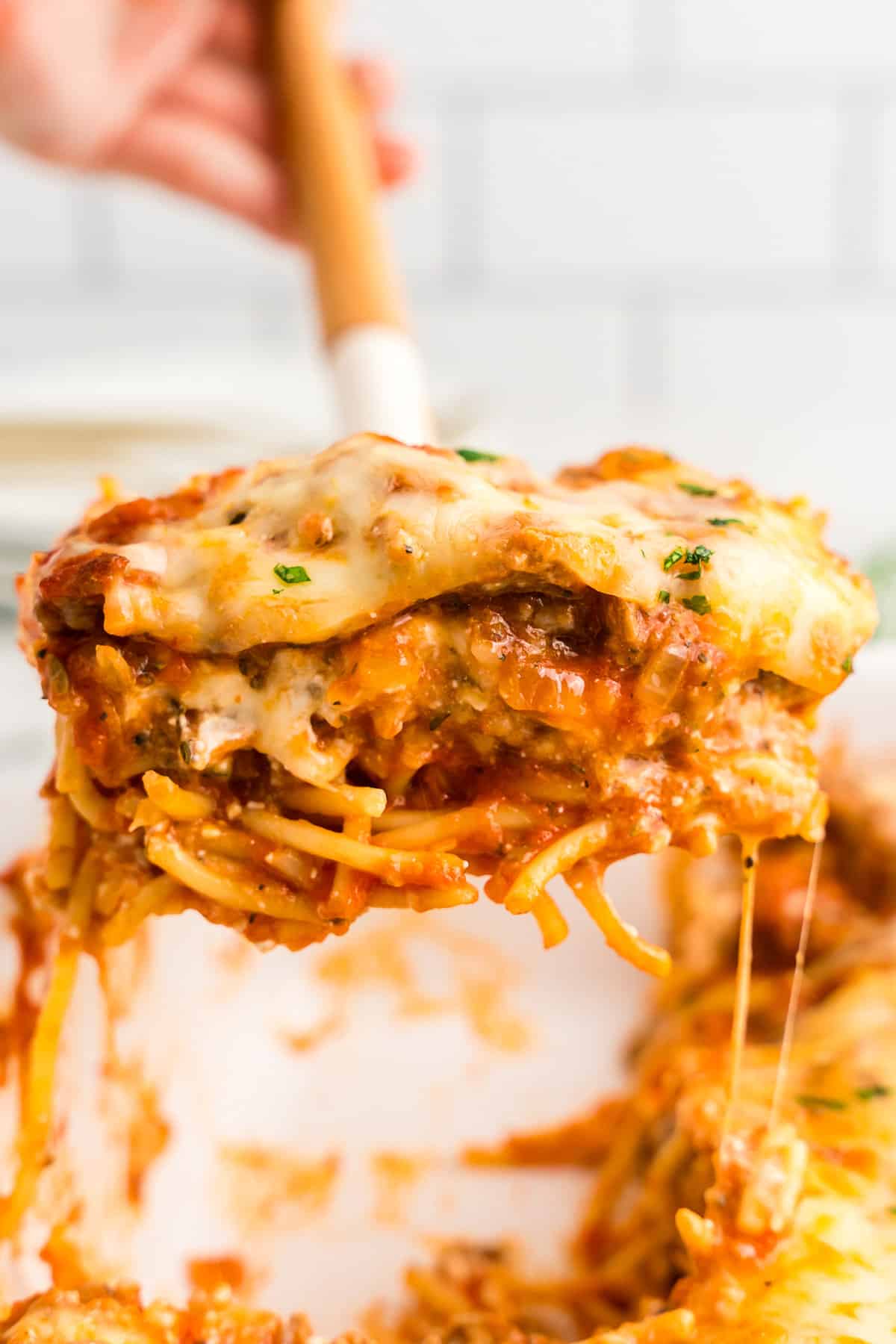 Using spatula to take a square piece of Million Dollar Spaghetti