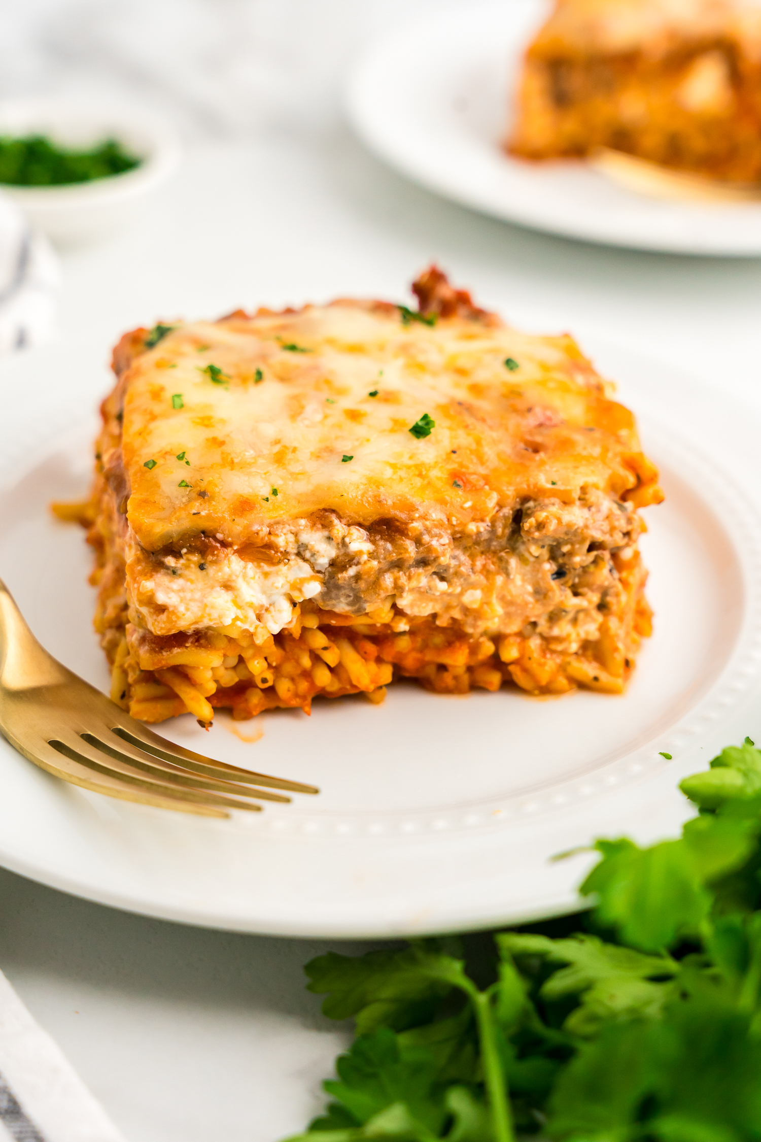 Baked Million Dollar Spaghetti cut into square on dinner plate