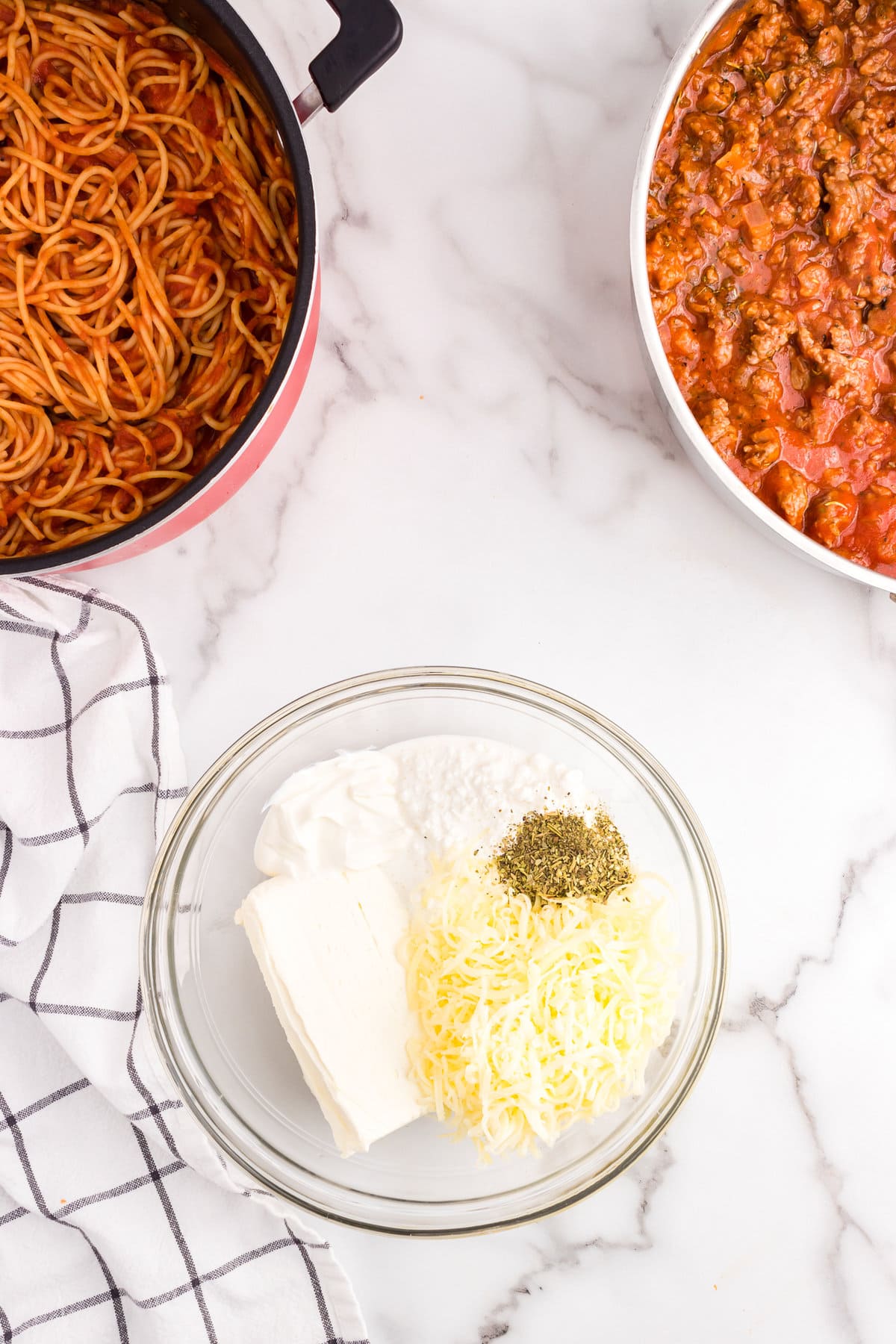 Combining cheeses in mixing bowl for Million Dollar Spaghetti Casserole