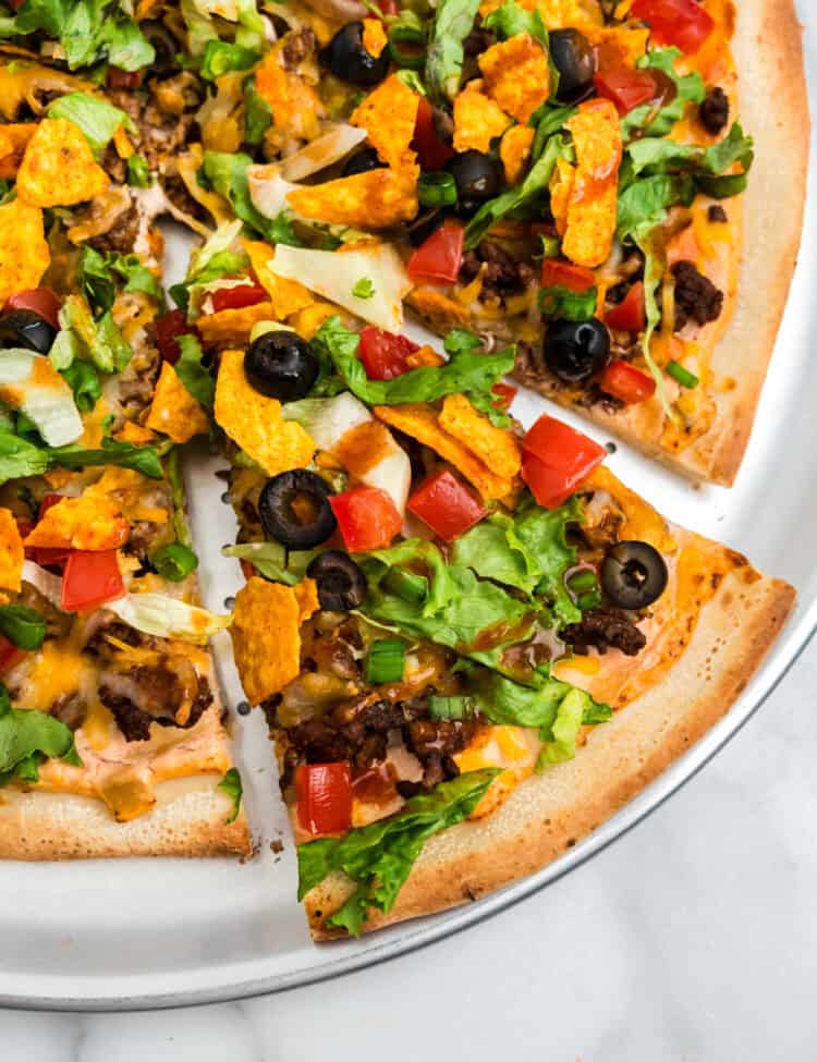 Taco Pizza on pizza pan with one slice cut
