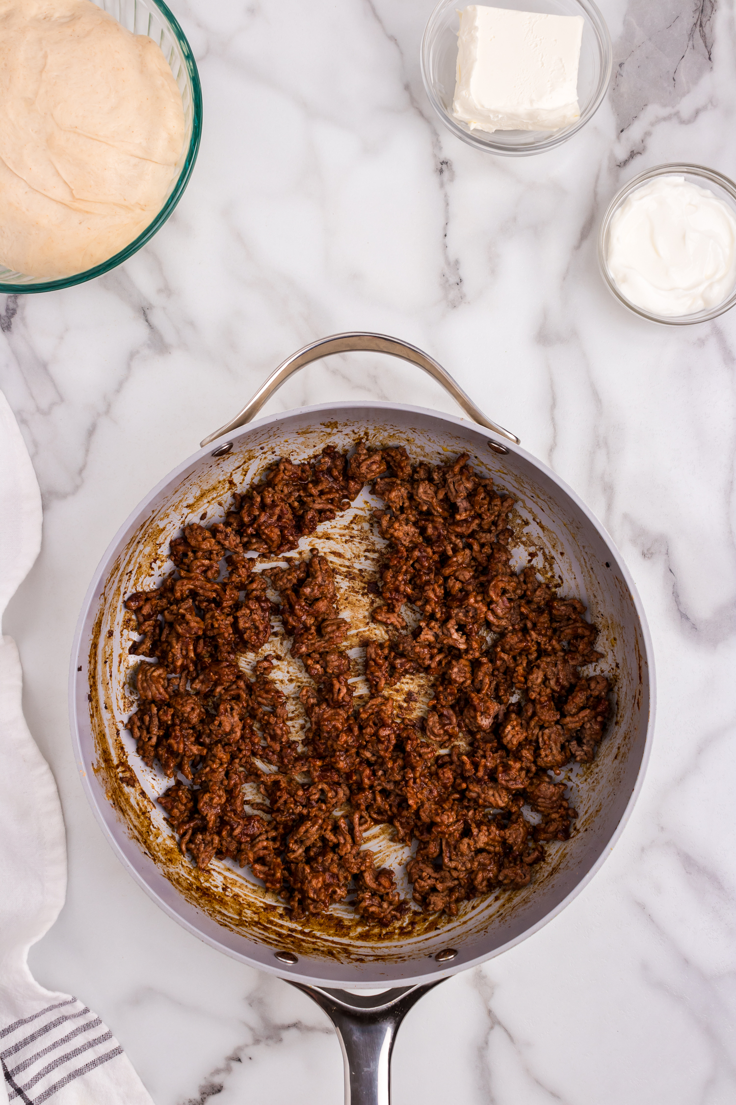 Browned hamburger with taco seasoning in skillet for Taco Pizza recipe