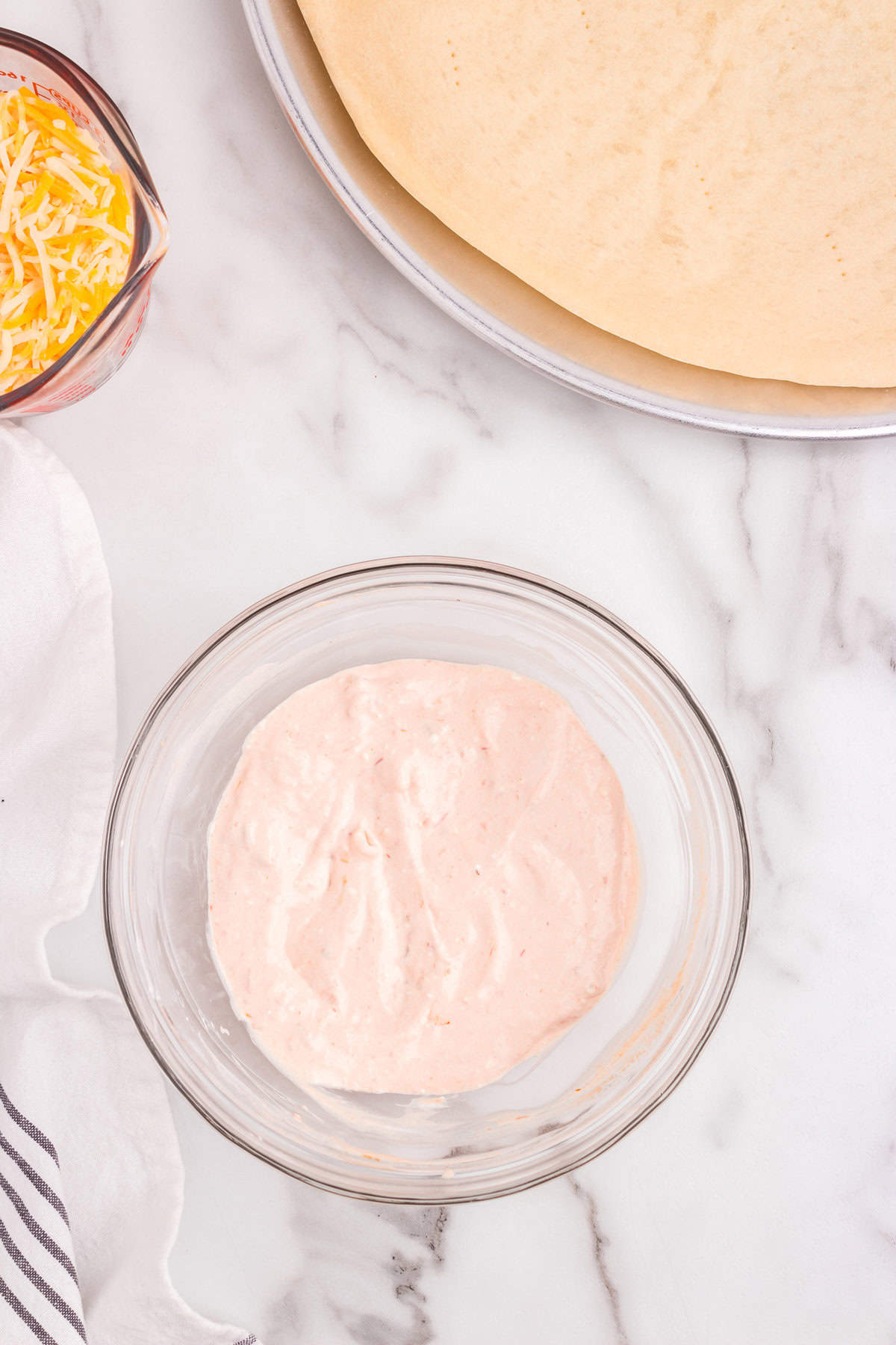 Blended cream cheese and sour cream with salsa in small bowl for Taco Pizza recipe