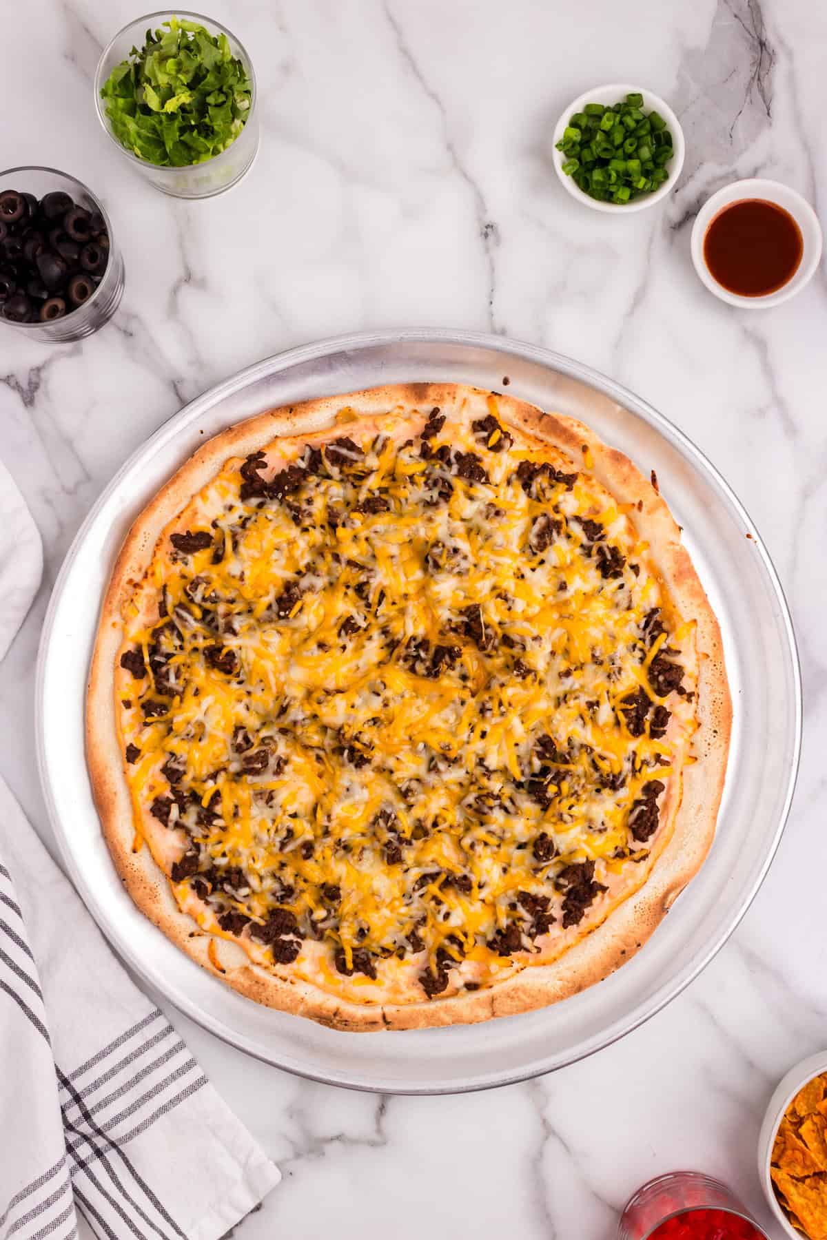 Baked Taco Pizza on pizza pan prior to adding toppings