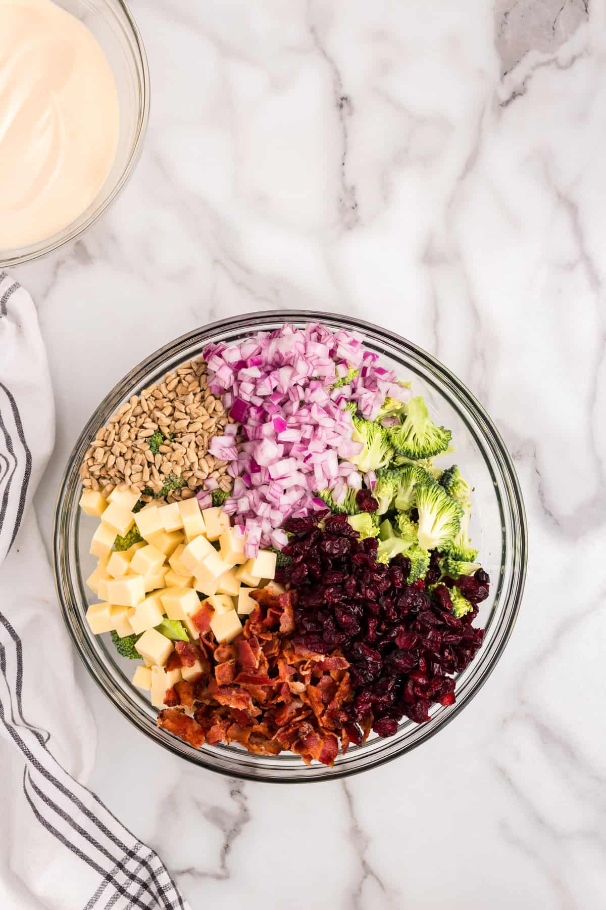 Ingredients for Broccoli Salad recipe ready to toss in glass mixing bowl