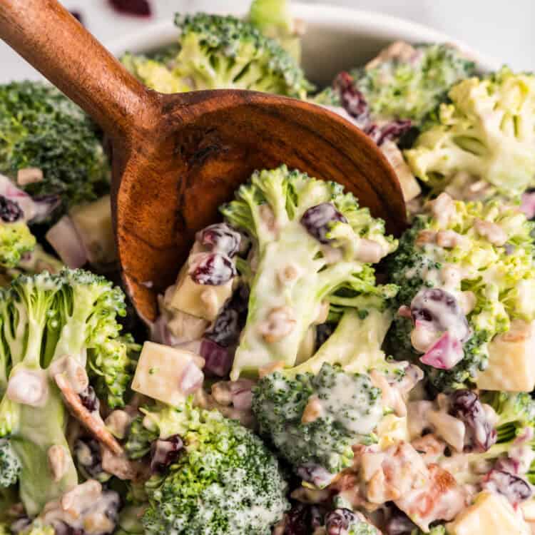 Using wooden spoon to scoop Broccoli Salad from bowl