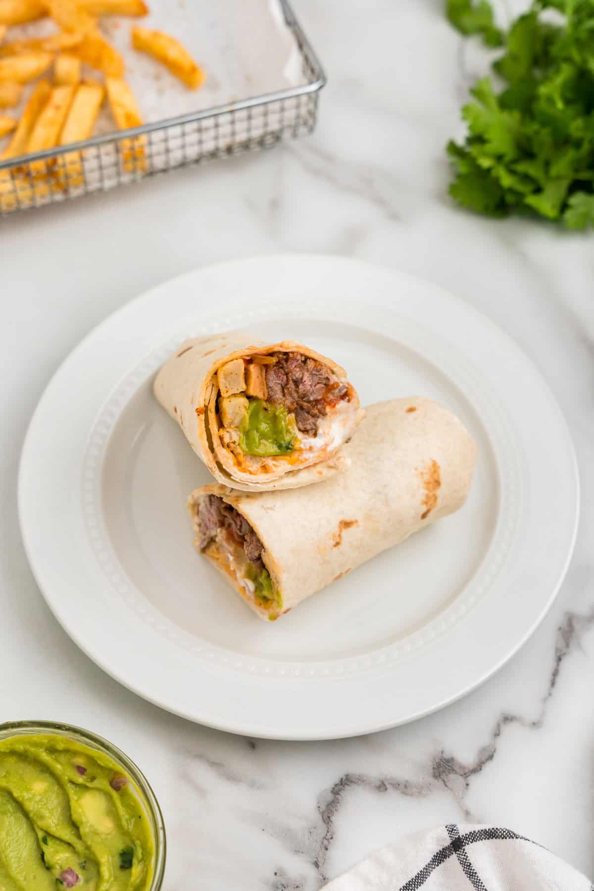 California Burrito cut in half arranged on serving plate