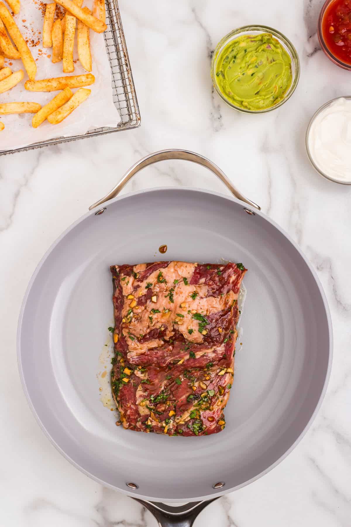 Seasoning steak in stovetop skillet for California Burrito