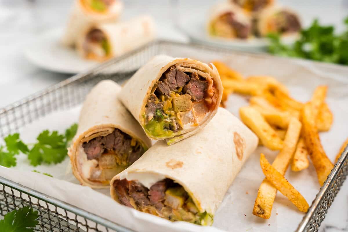 California Burrito sliced open with french fries in parchment-lined serving basket