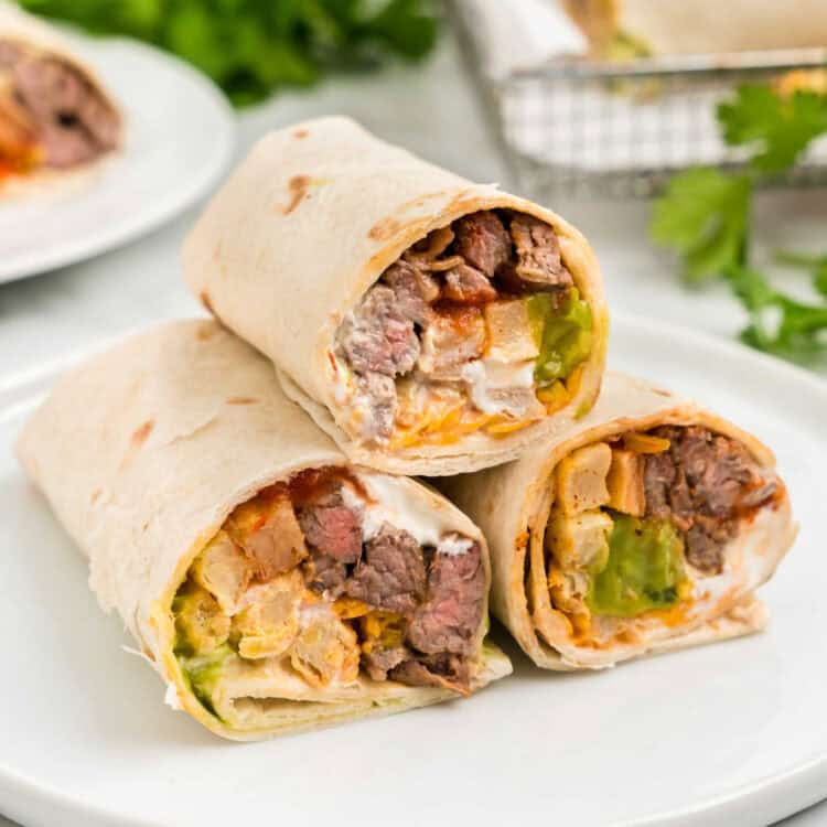 Closeup square image of California Burrito sliced open stacked on serving plate