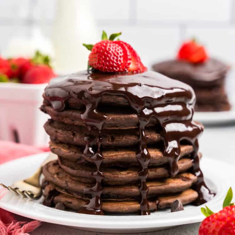 Stack of Chocolate Pancakes with chocolate syrup and a strawberry on top