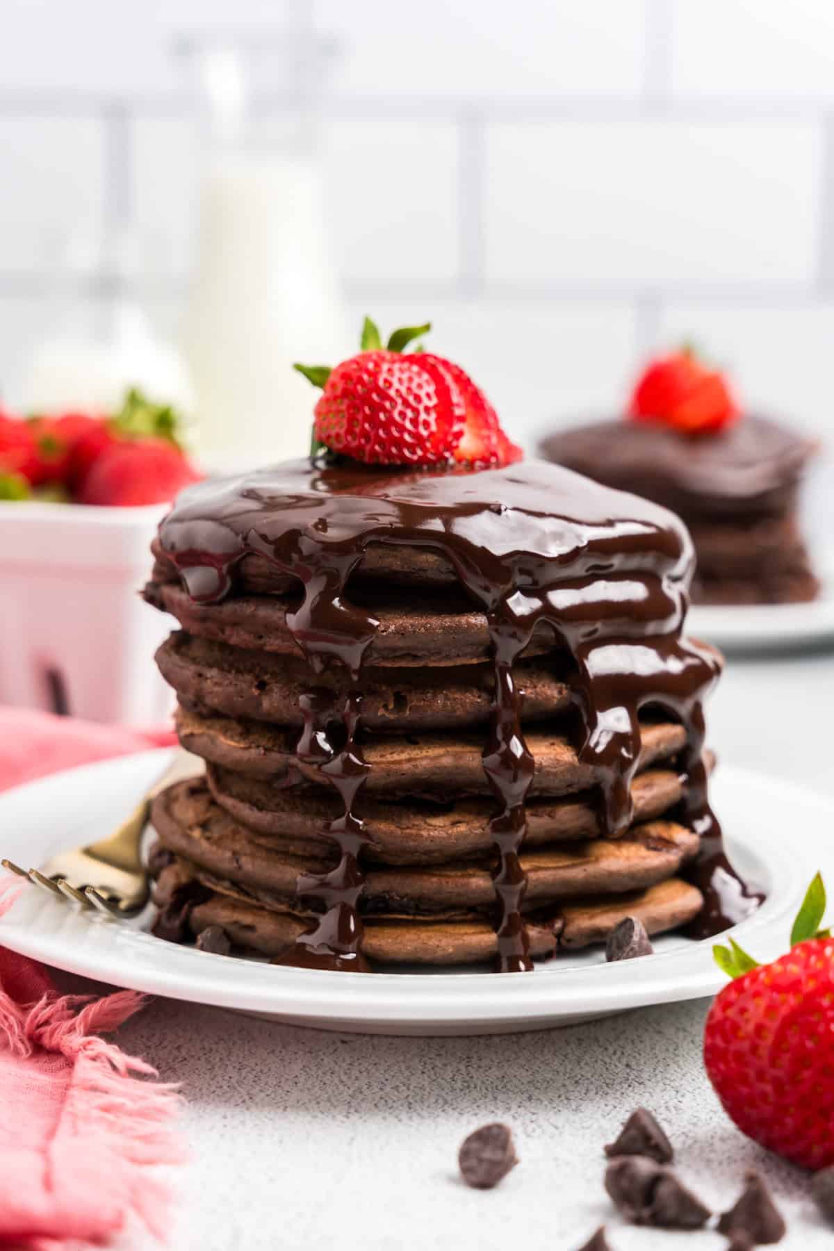 Stack of Chocolate Pancakes with chocolate syrup and a strawberry on top
