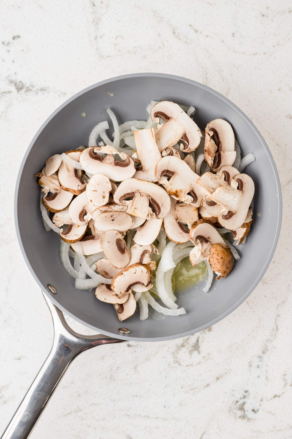 Mushrooms, onion, and seasonings in stovetop saute pan for Mushroom Swiss Burger recipe