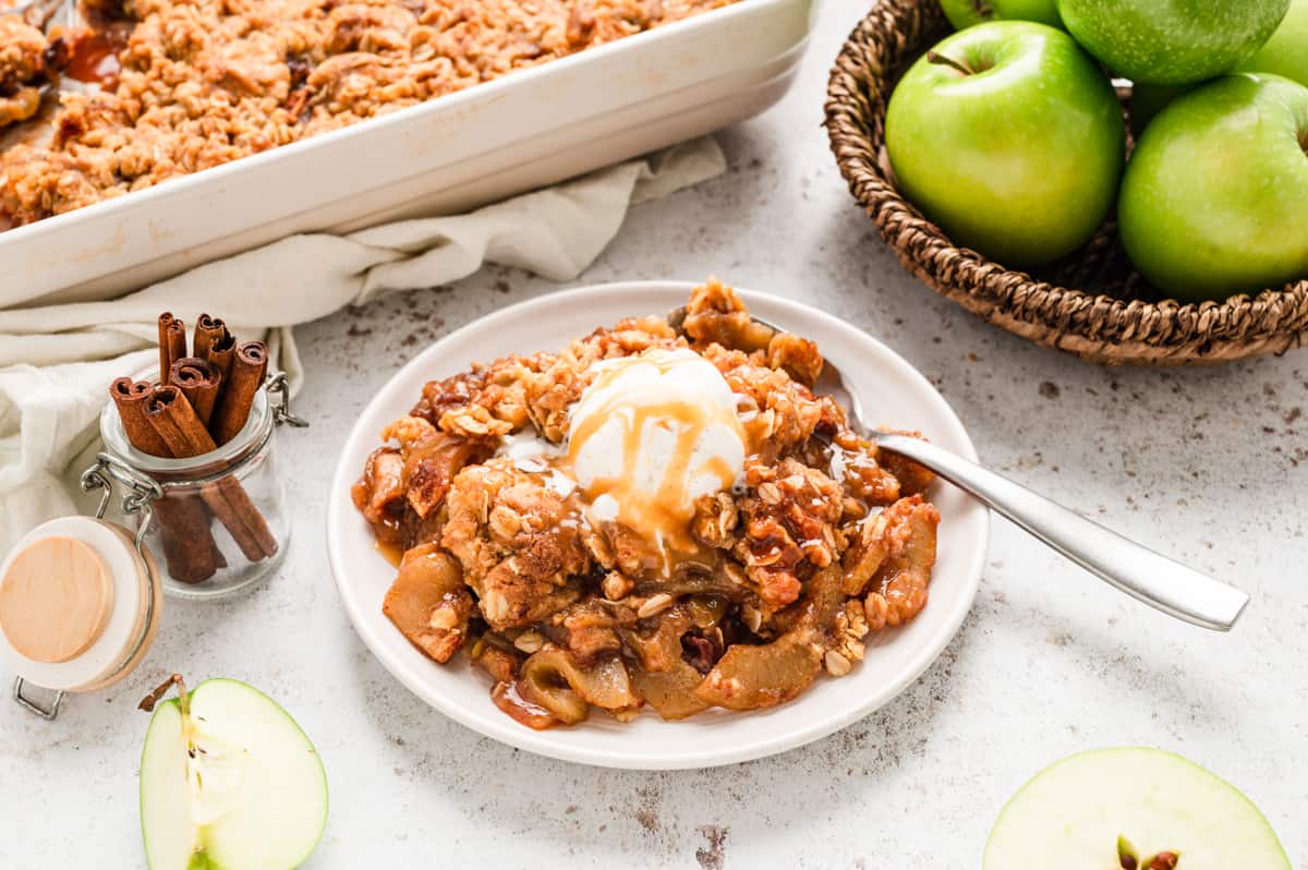 Apple Crisp in serving bowl topped with vanilla ice cream and caramel