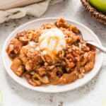Easy Apple Crisp Recipe in serving bowl topped with vanilla ice cream and caramel