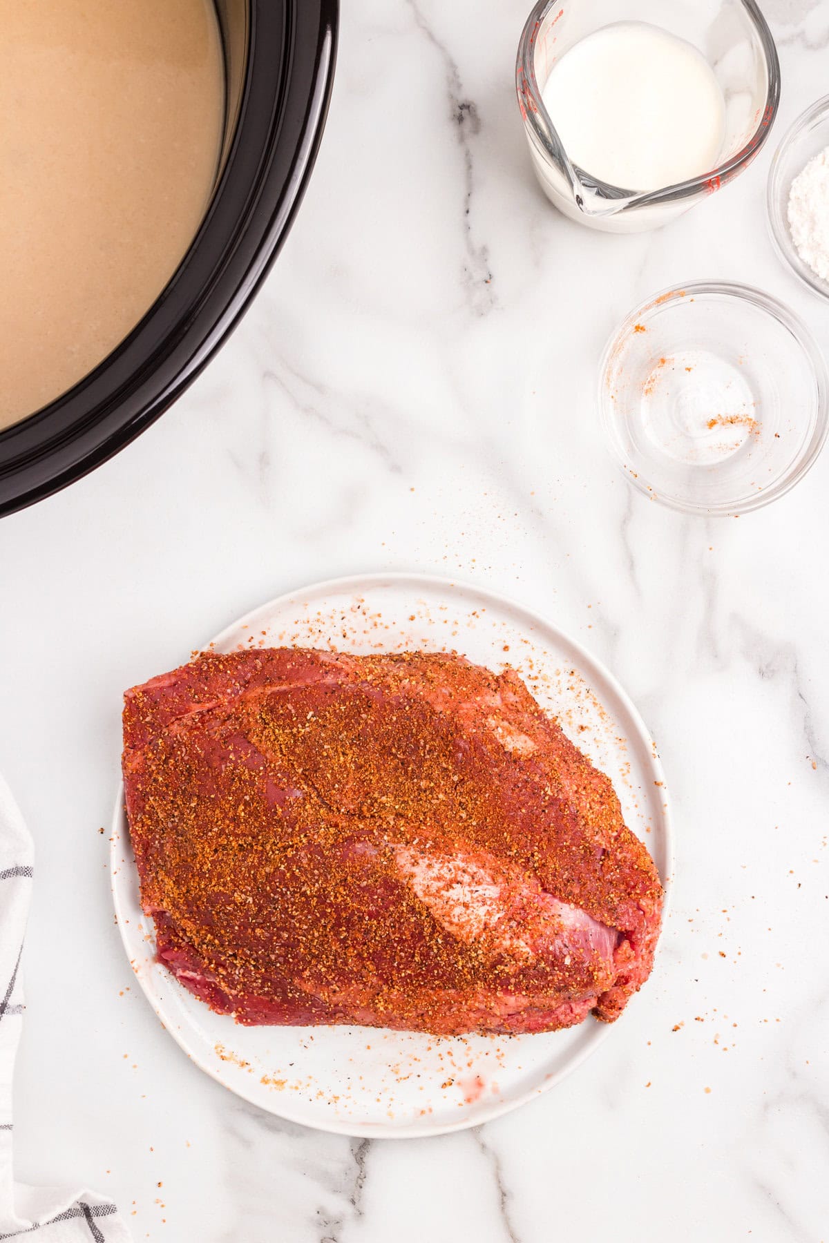Generously seasoning chuck roast for Crock Pot Beef and Noodles recipe