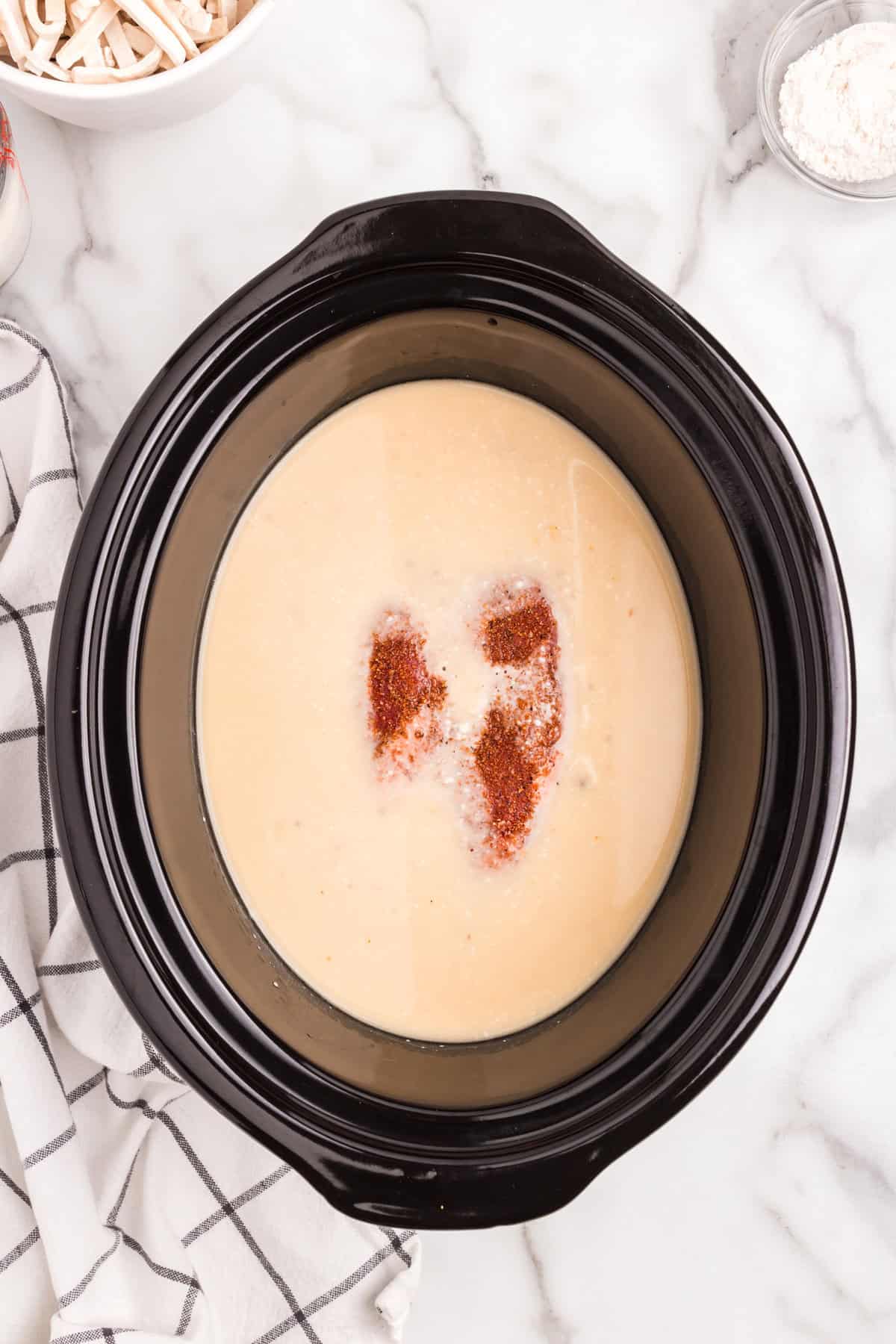 Adding seasoned roast to soup mixture in crock pot for Crock Pot Beef and Noodles